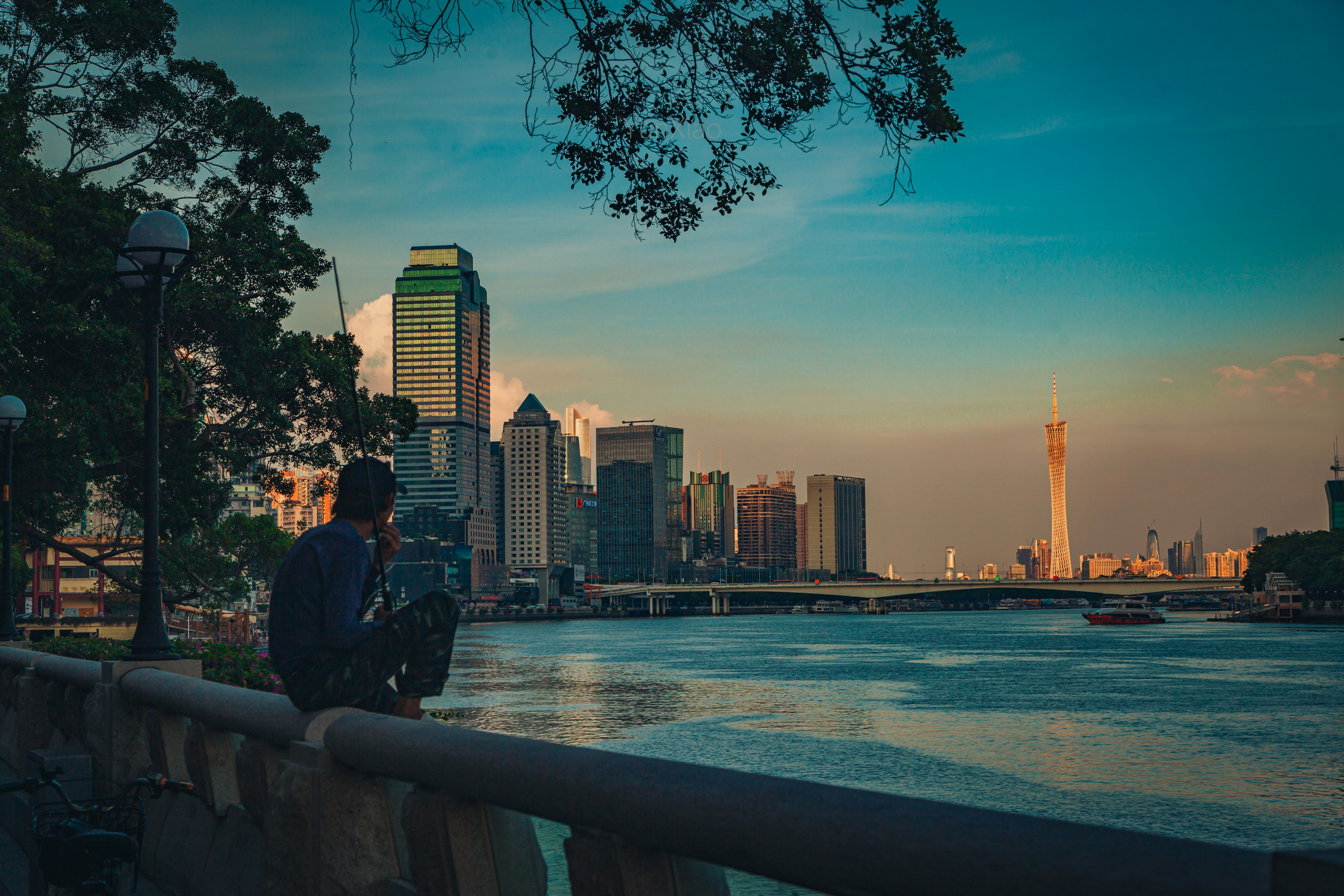 man and woman sitting on concrete bench near body of water during daytime